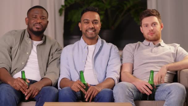 Šťastní usměvaví mužští přátelé s pivem doma — Stock video