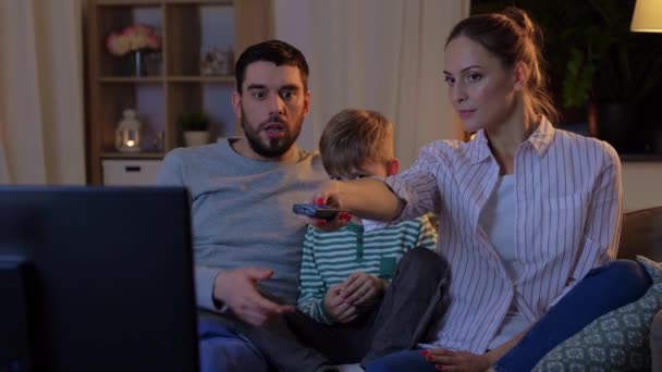 Glückliche Familie, die abends zu Hause fernsieht — Stockvideo