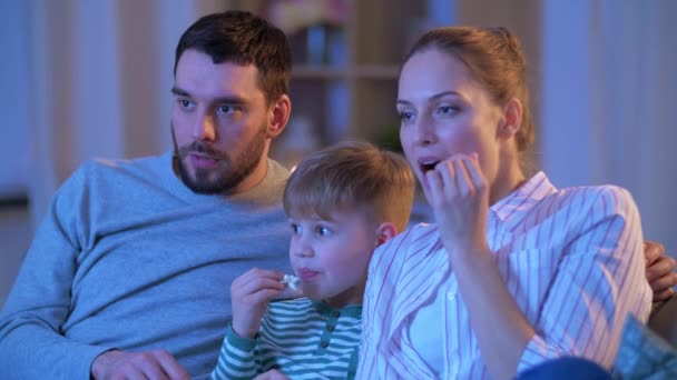 Evde tv izlerken patlamış mısır ile mutlu aile — Stok video