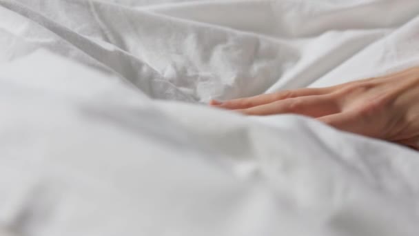 Main de femme serrant le linge de lit blanc ou la couverture — Video