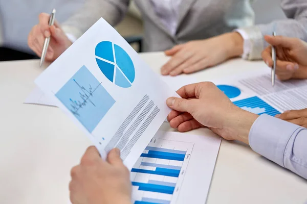 Equipo de negocios manos con bolígrafos y gráficos en la oficina —  Fotos de Stock