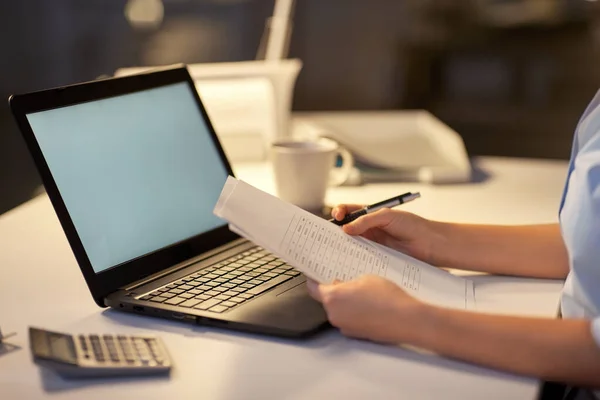 Femme avec ordinateur portable et papiers au bureau de nuit — Photo