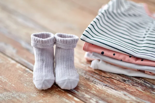 Close up of baby clothes on wooden table — Stockfoto