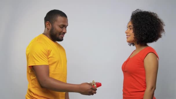 Lycklig afrikansk amerikansk par med röd presentförpackning — Stockvideo