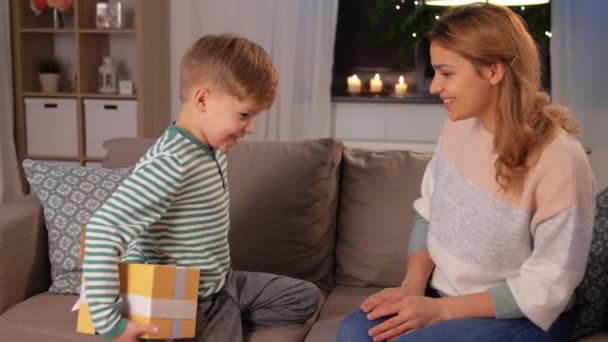 Pequeño hijo dando regalo a la madre en casa — Vídeos de Stock