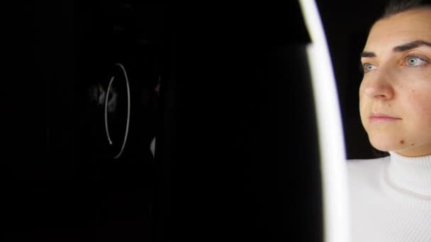 Жінка в окулярах над білим освітленням на чорному — стокове відео
