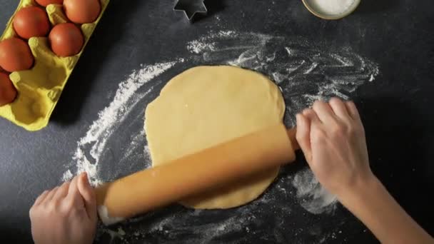 Руки со скалкой качения тесто на столе — стоковое видео