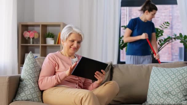 Old woman with tablet pc and housekeeper at home — Stock Video