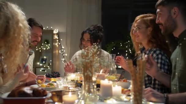 Amigos felices teniendo la cena de Navidad en casa — Vídeo de stock