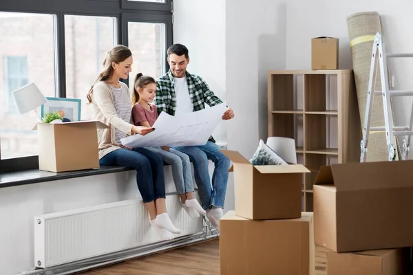 Happy family with blueprint moving to new home — Stock Photo, Image