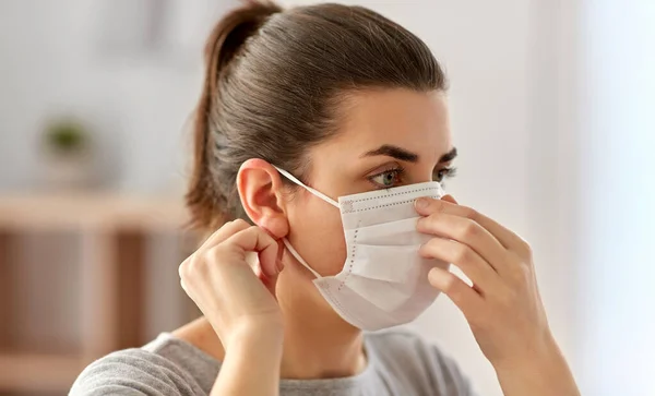 Ung kvinna bär skyddande medicinsk mask — Stockfoto