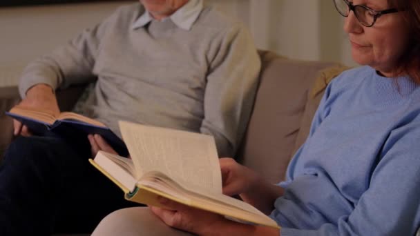 Щаслива старша пара читає книги вдома — стокове відео