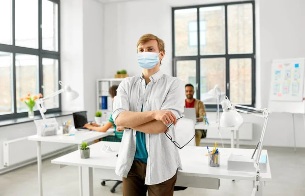 Uomo con gli occhiali in maschera medica in ufficio — Foto Stock