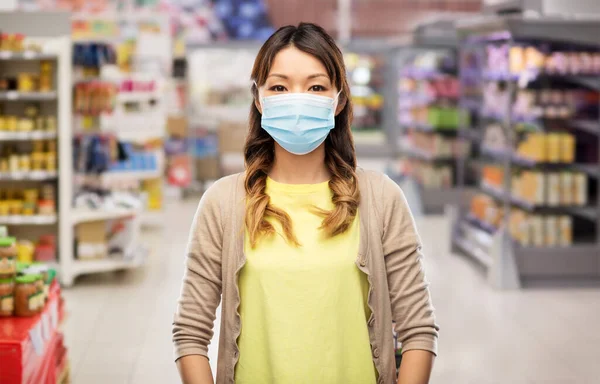 Aziatische jonge vrouw in beschermende medische masker — Stockfoto