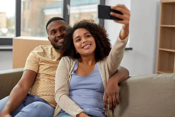 Gelukkig paar verhuizen naar nieuw huis en het nemen van selfie — Stockfoto