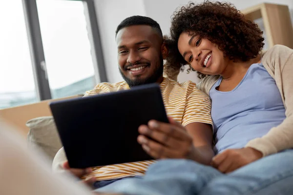 Ευτυχισμένο ζευγάρι με tablet PC υπολογιστή στο νέο σπίτι — Φωτογραφία Αρχείου