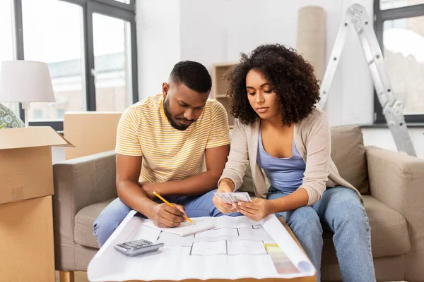 couple with blueprint counting money at home