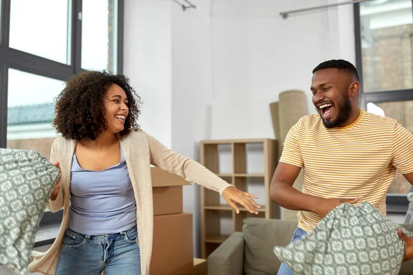 Glückliches Paar bei Kissenschlacht im neuen Zuhause — Stockfoto