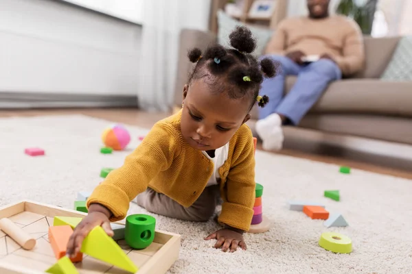 Африканська дівчинка грає з іграшковими блоками вдома — стокове фото