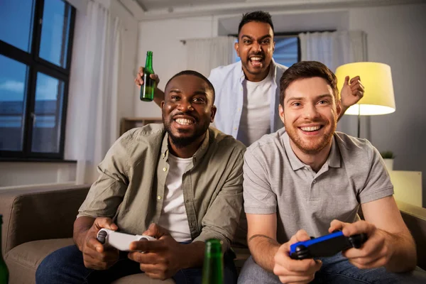 Amici felici che giocano ai videogiochi a casa di notte — Foto Stock
