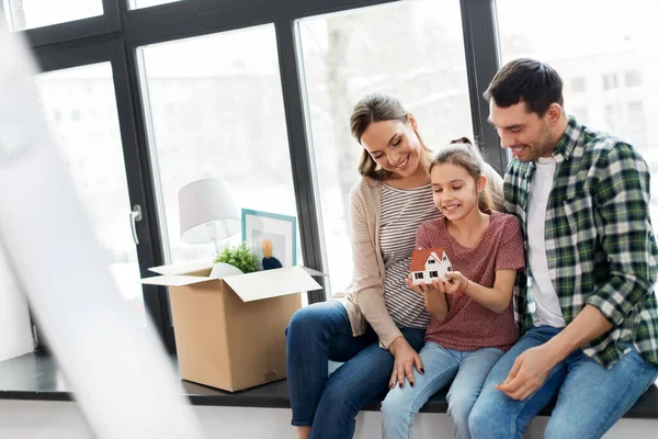 Šťastná rodina s modelem domu stěhování do nového domova — Stock fotografie