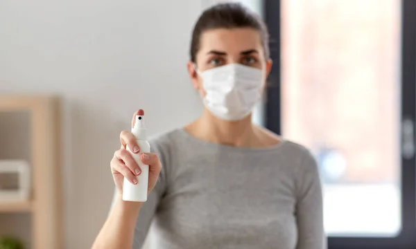 Zbliżenie kobieta w masce trzymając ręka dezynfektor — Zdjęcie stockowe