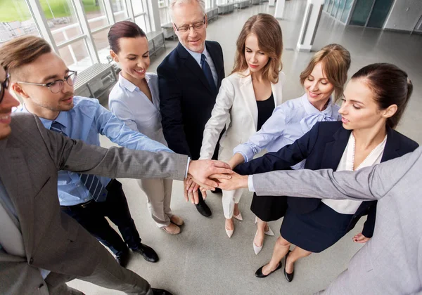 Glada affärsmän stapla händerna på kontoret — Stockfoto