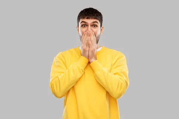 Shocked young man covering his mouth with hands — Stock Photo, Image