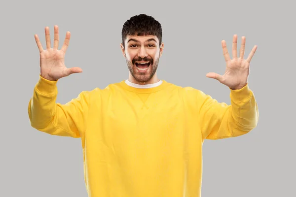 Mosolygós fiatalember mutatja a kezét vagy tíz ujját — Stock Fotó