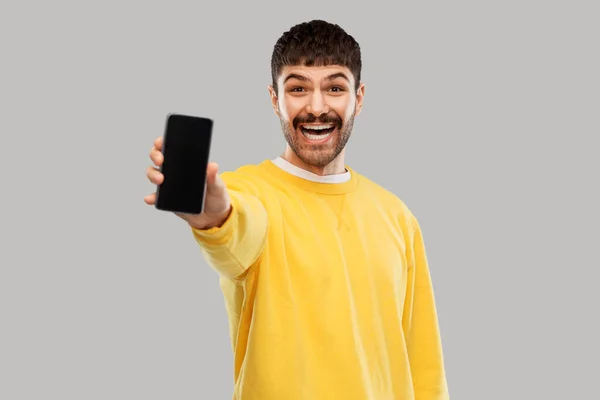 Happy smiling young man showing smartphone — Stok fotoğraf