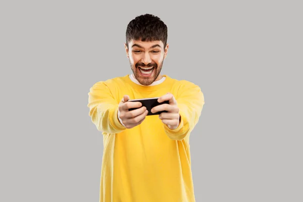 Gelukkig lachen jonge man met smartphone — Stockfoto