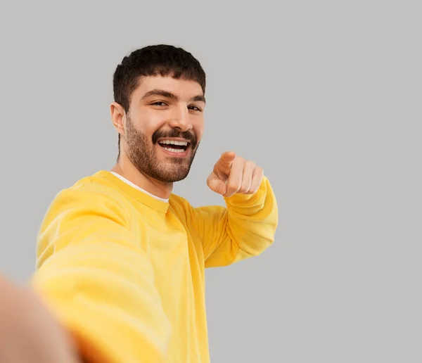 Glücklicher junger Mann in gelbem Sweatshirt macht Selfie — Stockfoto