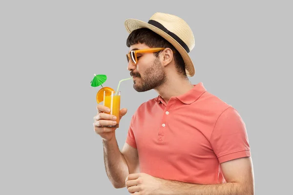 Людина в солом'яному капелюсі п'є апельсиновий сік коктейль — стокове фото