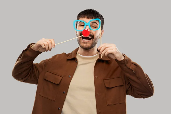 Feliz homem sorridente com óculos e nariz de palhaço vermelho — Fotografia de Stock