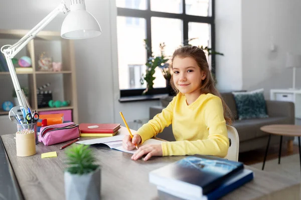 Schülerin mit Buch zu Hause zum Notizbuch — Stockfoto