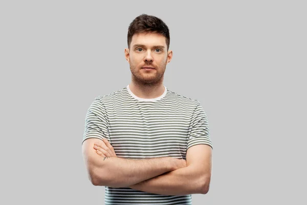 Junger Mann im gestreiften T-Shirt mit verschränkten Armen — Stockfoto