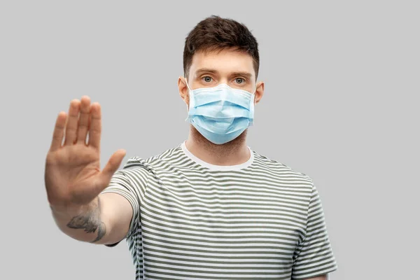 Людина в захисній медичній масці робить стоп жест — стокове фото