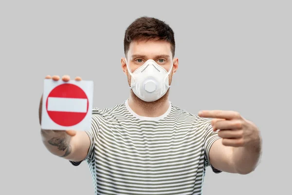 Hombre en máscara respiratoria mostrando señal de stop —  Fotos de Stock