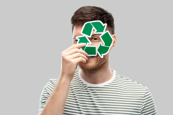 Jovem sorridente segurando sinal de reciclagem verde — Fotografia de Stock