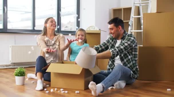 Счастливая семья играет с пенным арахисом в новом доме — стоковое видео
