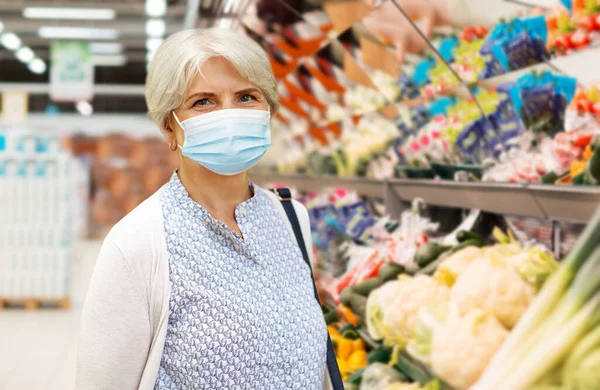 Donna anziana in maschera medica al supermercato — Foto Stock