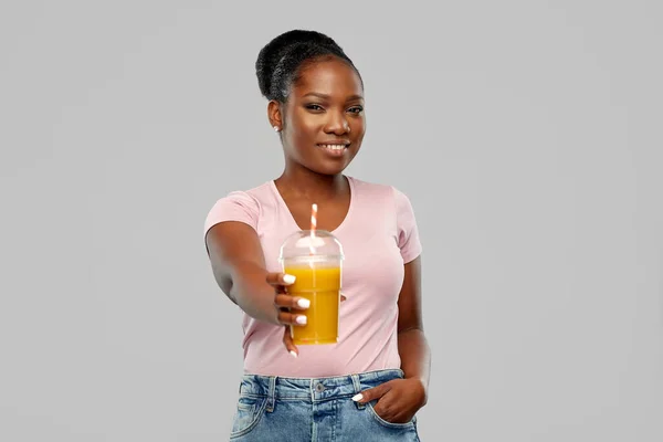 Happy african american woman drinking orange juice — Stock Photo, Image