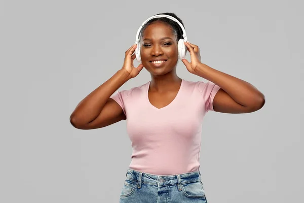 Mulher africana em fones de ouvido ouvindo música — Fotografia de Stock