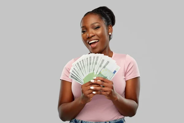 Mujer afroamericana feliz con el dinero del euro — Foto de Stock