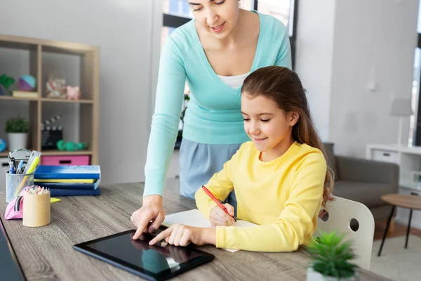 Мать и дочь с планшетным ПК делает домашнее задание — стоковое фото