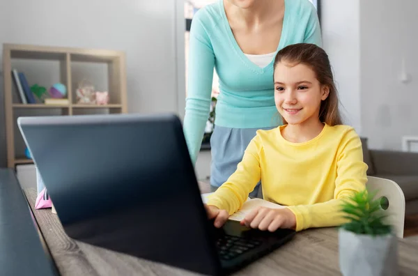 Mãe e filha com laptop fazendo lição de casa — Fotografia de Stock