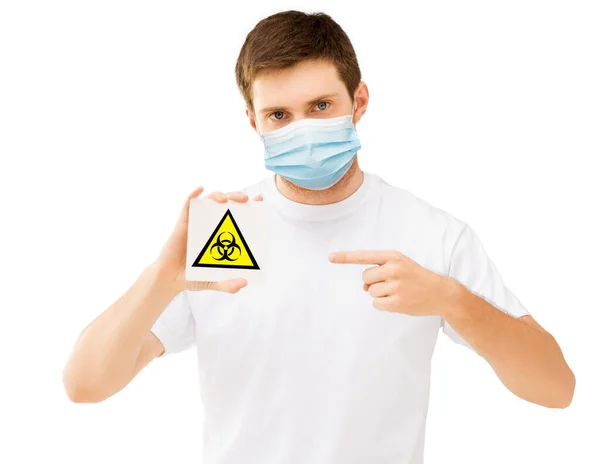 Hombre con máscara médica sosteniendo señal de precaución boihazard —  Fotos de Stock