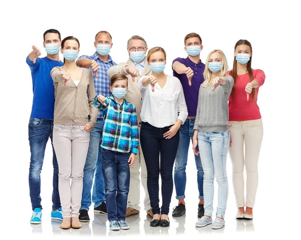 Lidé v lékařských maskách ukazující palce dolů — Stock fotografie