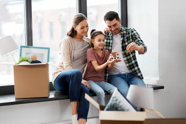 happy family with house model moving to new home