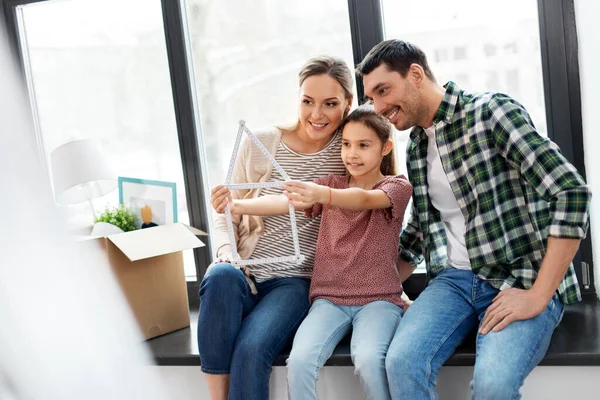 Familia feliz con regla plegable mudarse a un nuevo hogar —  Fotos de Stock